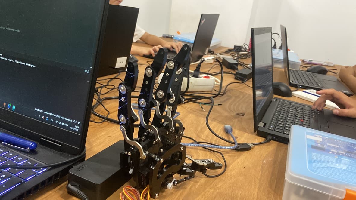 Alumnos programando mano robótica